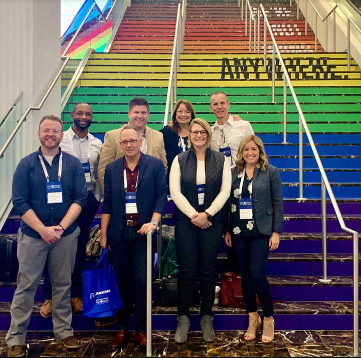 group standing on rainbow-colored stairs